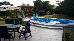 diepe tuin met zwembad en diverse zitjes